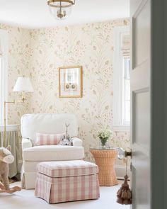 a baby's room with pink and white wallpaper