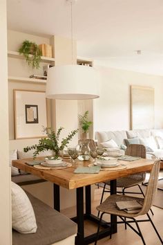 a dining room table with plates and bowls on it, surrounded by couches in the background