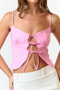 This pink front tie cami top is a total vibe! 😍 The soft pastel pink is perfect for brightening up your outfits, and the front tie detail adds that extra cute touch. With adjustable spaghetti straps and lightweight fabric, it's all about comfort and style. Pair it with your go-to high-waisted jeans or a flirty skirt for a look that's effortlessly chic. Whether you're heading to brunch or out with friends, this cami is your new go-to for a fresh, fun look! 🌟💖 Feminine Cotton Tank Top With Tie Straps, Pink Tops With Built-in Bra For Day Out, Summer Tank Top With Tie Back For Spring, Summer Tie Back Tank Top For Spring, Spring Tie-back Tank Top, Trendy Camisole With Built-in Bra For Spring, Pink Camisole For Spring Vacation, Feminine Summer Tank Top With Adjustable Straps, Spring Tank Top With Knotted Straps