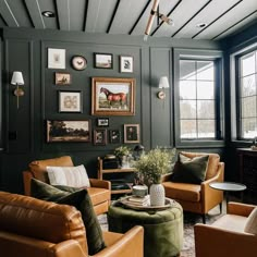 a living room with leather furniture and pictures on the wall above it's windows