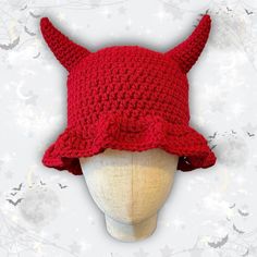 a crocheted red hat with horns on it