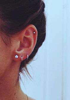 a close up of a person wearing ear piercings