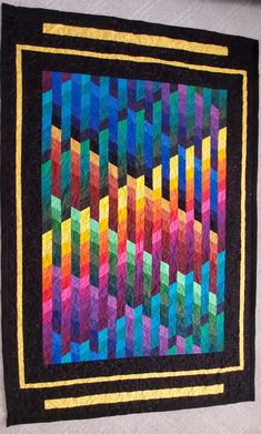 a multicolored quilt hanging on the wall