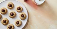 chocolate chip cookies are arranged on a white plate next to a glass of red wine