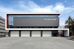 an empty parking lot in front of a large building with two garages on each side