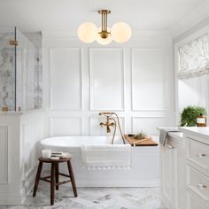 a bathroom with marble floors and white walls, along with a claw foot tub in the center