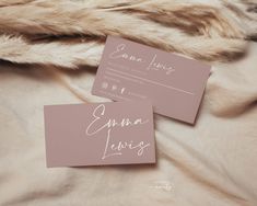 two business cards sitting on top of a bed next to a furnishing area