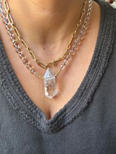 This stunning Clear Quartz Crystal Necklace is the perfect blend of elegance and spiritual energy. Featuring a striking, raw clear quartz point pendant, this necklace is hand-strung with clear quartz beads and gold-tone accents, adding a radiant touch to any outfit. The necklace is both a statement piece and a tool for spiritual healing, designed to amplify positive energies and promote mental clarity. Product Details: *Crystal: Natural Clear Quartz Point *Pendant Size: Approx. 5cm *Chain: Clear Quartz Beads with Gold-tone Spacer Beads *Chain Length: 21cm *Handmade with Love Properties of Clear Quartz: Clear Quartz is known as the "Master Healer," amplifying energy, thoughts, and the effects of other crystals. It is a highly prized stone for those looking to enhance their focus, clarity, a Wrapped Crystal Necklace, Chain Layering, Natural Gemstone Necklace, Necklace Birthstone, Clear Quartz Point, Quartz Crystal Necklace, Spiritual Energy, Quartz Beads, Healing Energy