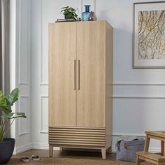 a tall wooden cabinet sitting in a living room next to a plant and potted plant