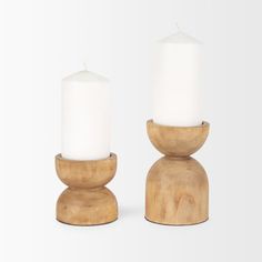 two wooden candle holders with white candles in them