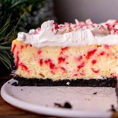 a piece of cheesecake with whipped cream and candy canes on top is sitting on a plate