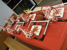 some basketballs are on a table with red cloth and white net around them for display