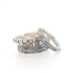 This is the second-most narrow of my Memento Mori rings at 3.3mm wide. This is the cute skeleton with the shy knees! The Skeleton is flanked by intertwined hearts on one side and about 1/2 of the band is a blank half round band. Perfect for when you have to act like a normie! Unlike my Enameled Memento Mori Rings, these are oxidized instead of the longer enameling process. Once oxidized, they are given a brushed finish with a light layer of Renaissance Wax to keep the dark patina as long as poss Symbolic Engraved Skull Ring, Engraved Silver Skull Open Ring, Collectible Engraved Skull-shaped Rings, Momento Mori Skull Ring, Unique Hand-cast Skull Ring, Memento Mori Ring, Skeleton Ring, Intertwined Hearts, Cute Skeleton