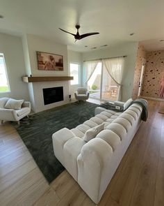 a large living room with white furniture and wood floors