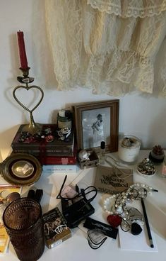 a table topped with assorted items and a framed photo on top of it next to a window