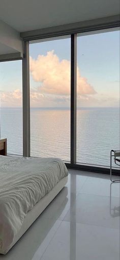 a bedroom with a large window overlooking the ocean