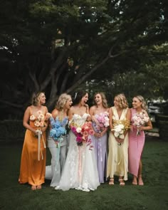 a group of women standing next to each other on top of a lush green field