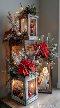 christmas decorations are displayed in small wooden boxes on top of a table with lights and ornaments