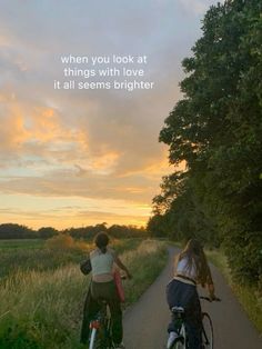 two people riding bikes down a road with the sun setting in the background and an image of