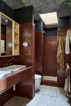 the bathroom is decorated in brown tones and features an interesting tile pattern on the walls