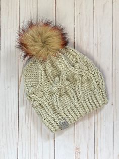 a knitted hat with a fur pom