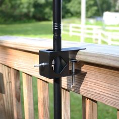 an umbrella is attached to the side of a wooden fence with a screwdriver