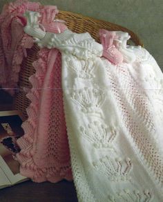 there is a crocheted blanket on the floor next to a basket and book