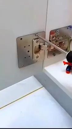 a stuffed animal sitting on top of a white counter next to a metal door handle