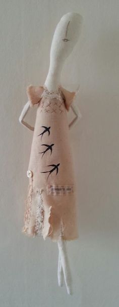 a stuffed animal hanging from the ceiling with birds painted on it's body and wings