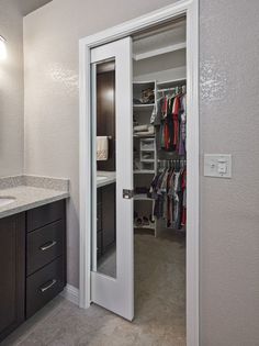 a walk in closet that is next to a sink