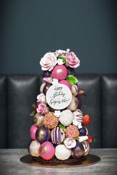 a cake decorated with chocolates and flowers on a table