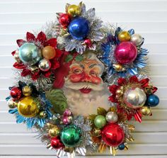 a christmas wreath with an image of santa claus surrounded by ornaments and tinsels