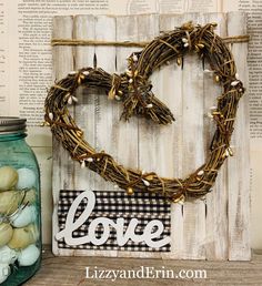 a heart shaped sign sitting on top of a table next to a jar filled with eggs