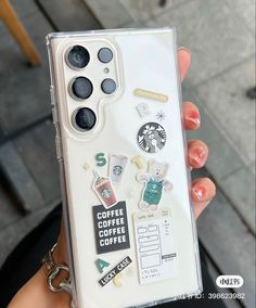 a person holding up a phone case with stickers on the back and side of it