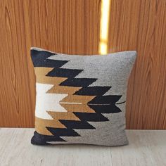 a pillow sitting on top of a white table next to a wooden paneled wall