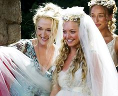 two women dressed in wedding clothes and veils