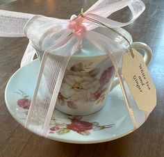 a tea cup and saucer with a ribbon tied around it