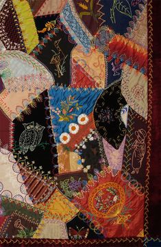 a close up of a patchwork quilt with many different colors and designs on it