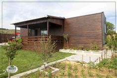 a wooden house sitting on top of a lush green field