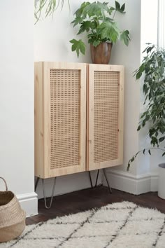 a wooden cabinet sitting next to a potted plant