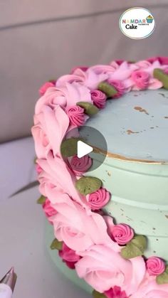 a cake decorated with pink flowers and green leaves