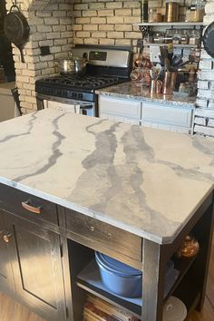 a kitchen island with marble top in front of an oven