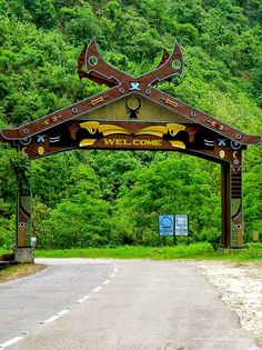 an entrance to the wild come park with mountains in the background