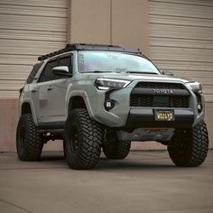 a grey toyota truck parked in front of a garage door