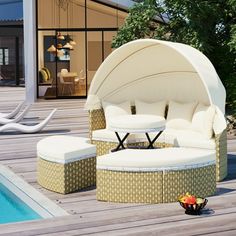 a white couch sitting on top of a wooden deck next to a swimming pool