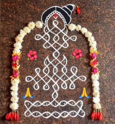 an intricately decorated wall hanging with flowers and beads on it's side, in the shape of a tree