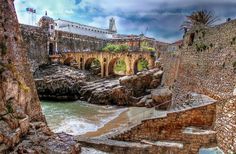 an old stone bridge spanning the width of a body of water