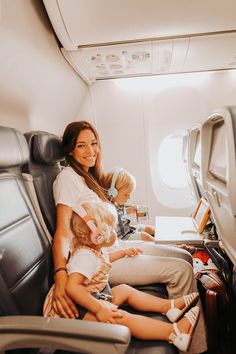 a woman and two children sitting on an airplane seat