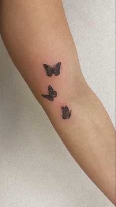 a woman's arm with three butterflies on it