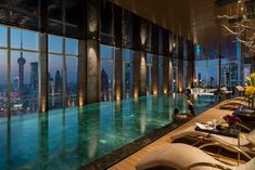 an advertisement for the four seasons shanghai pudong hotel in china, with a pool and cityscape